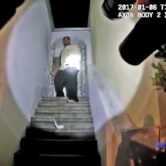 This image shows a Black man standing on stairs in front of a residence.