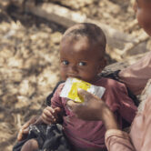 A mother giving supplementary nutrition products to her 6-month-old daughter in Madagascar.
