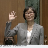 Saule Omarova raises her right had before the Senate Banking Committee.