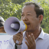 Rong Chhun uses a megaphone during a protest.