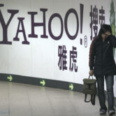 A woman walks past a Yahoo sign in a Beijing subway.
