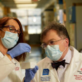 Drs. Maria Bottazzi and Peter Hotez examine a dose of Corbevax Covid-19 vaccine in a vial.