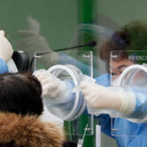 A medical worker takes a sample at a Covid-19 clinic in South Korea.