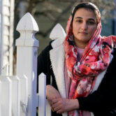 Haseena Niazi, a 24-year-old from Afghanistan, poses outside her home.