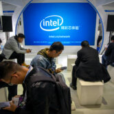 Attendees look at their smartphones at Intel's booth at the PT Expo in Beijing.