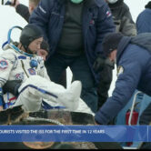 A rescue team helps spaceflight participant Yusaku Maezawa get out of a capsule.
