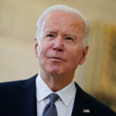 President Joe Biden listens to a reporter's question in the State Dining Room.
