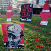 Posters stand on a lawn outside the Hennepin County Government Center.