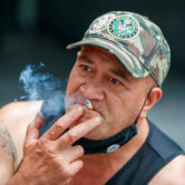 A man sits while smoking in Auckland, New Zealand.