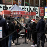 People wait in line at a mobile Covid-19 testing site in Times Square.