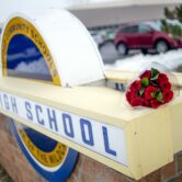 Roses are placed outside the site of a school shooting in Oxford, Mich.
