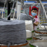 A worker gathers cotton yarn at a textile manufacturing plant in China's Xinjiang.