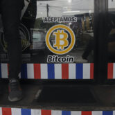 A Bitcoin sticker on a barbershop window in El Salvador.