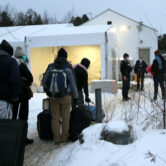 Migrants line up at the U.S.-Canada border.