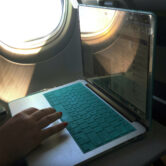 A passenger uses a laptop aboard a commercial airline flight.