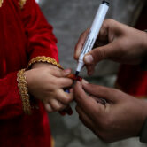 A health worker marks the finger of a child after receiving the polio vaccine in Pakistan.