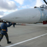 A Russian air force pilot walks to a Su-30 fighter jet.