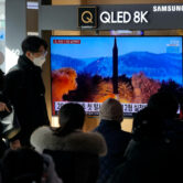 People watch a TV showing an image of a North Korean missile launch.