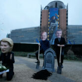 Climate activists pose with masks of EU leaders.