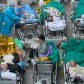Patients lie on hospital beds as they wait at a temporary holding area in Hong Kong.