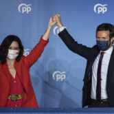 Isabel Díaz Ayuso and Pablo Casao wave outside of Popular Party headquarters.