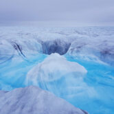 Meltwater flowing down a crack in the Greenland ice sheet