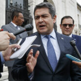 Juan Orlando Hernández answers questions as he leaves a meeting in Washington.