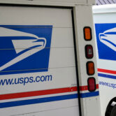 USPS mail delivery vehicles parked outside a post office in Nebraska.