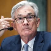 Fed Chair Jerome Powell sits near a microphone.
