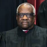 Clarence Thomas sits during a group photo at the Supreme Court.