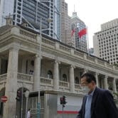 A man wearing a mask walks past the Court of Final Appeal in Hong Kong.