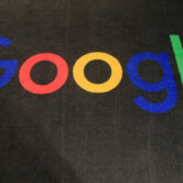 The Google logo is displayed on a carpet in an entrance hall.