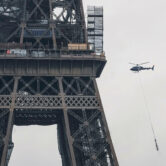 A helicopter transports a new antenna for the Eiffel Tower in Paris.