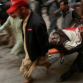 An injured man is taken from the site of a bomb explosion at a Shiite mosque in Pakistan.