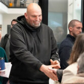 John Fetterman visits with people attending a Democratic Party event.
