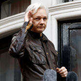 Julian Assange greets supporters from a balcony of the Ecuadorian embassy in London.