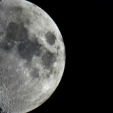 Impact craters cover the surface of the moon, seen from Berlin, Germany.