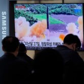 People in South Korea watch a TV showing a file image of a North Korean missile launch.