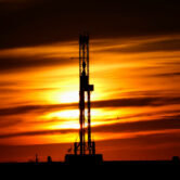 An oil drilling rig is pictured at sunset in El Reno, Okla.