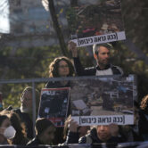 Protesters hold pictures of demolished homes in Sheikh Jarrah.