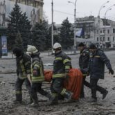 Workers carry a victim’s body after shelling in Ukraine