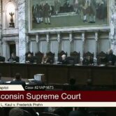 Wisconsin justices prepare for arguments in the high court's hearing room in Madison.