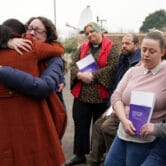 Women hug after the release of a report on the U.K. maternity services scandal.