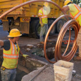 Workers prepare to replace older water pipes with a new copper one in Newark, N.J.