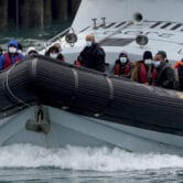 Migrants are brought to shore in a vessel in Britain