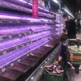 Customers look through empty shelves at a supermarket in Shanghai, China.