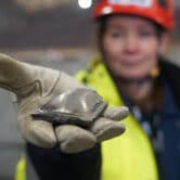 A researcher holds a piece of hot briquetted iron ore in Sweden.