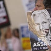 Supporters of WikiLeaks founder Julian Assange hold placards as they gather in London.