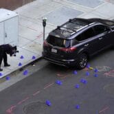 A crime scene investigator photographs evidence markers.