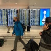 Masked travelers walk through Seattle-Tacoma International Airport